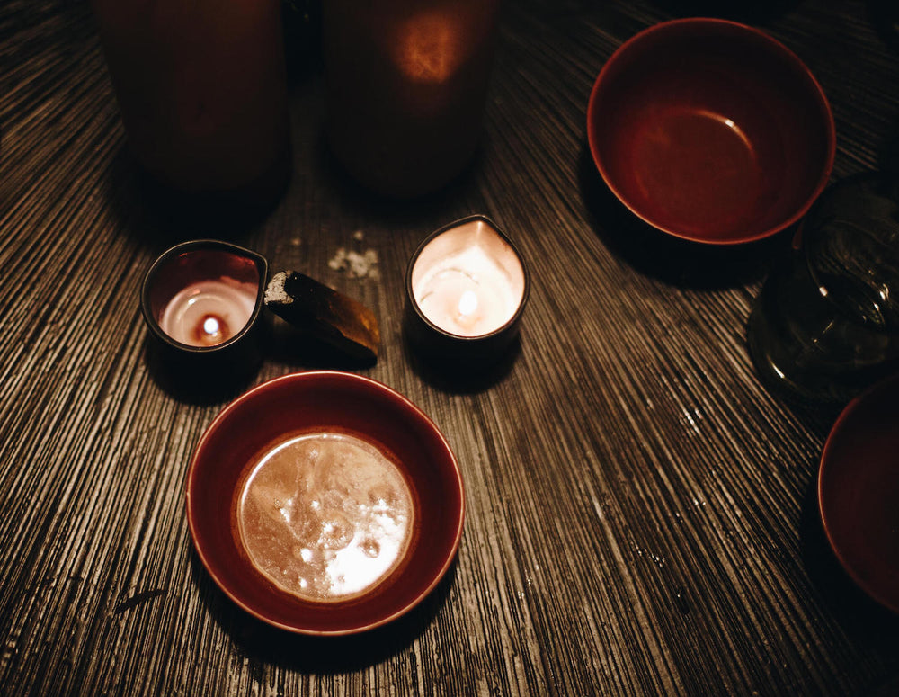Bol de cacao avec bougies sur une natte en bambou