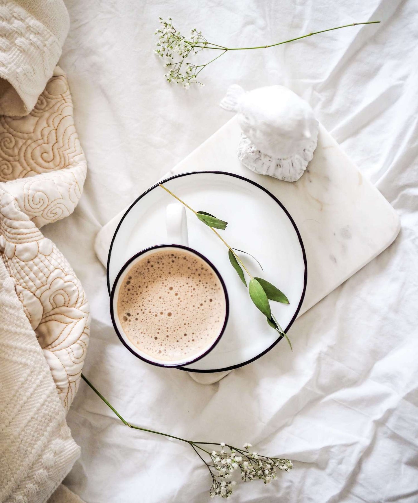 tasse de cacao chaud avec des fleurs de baby's breath sur du lin blanc